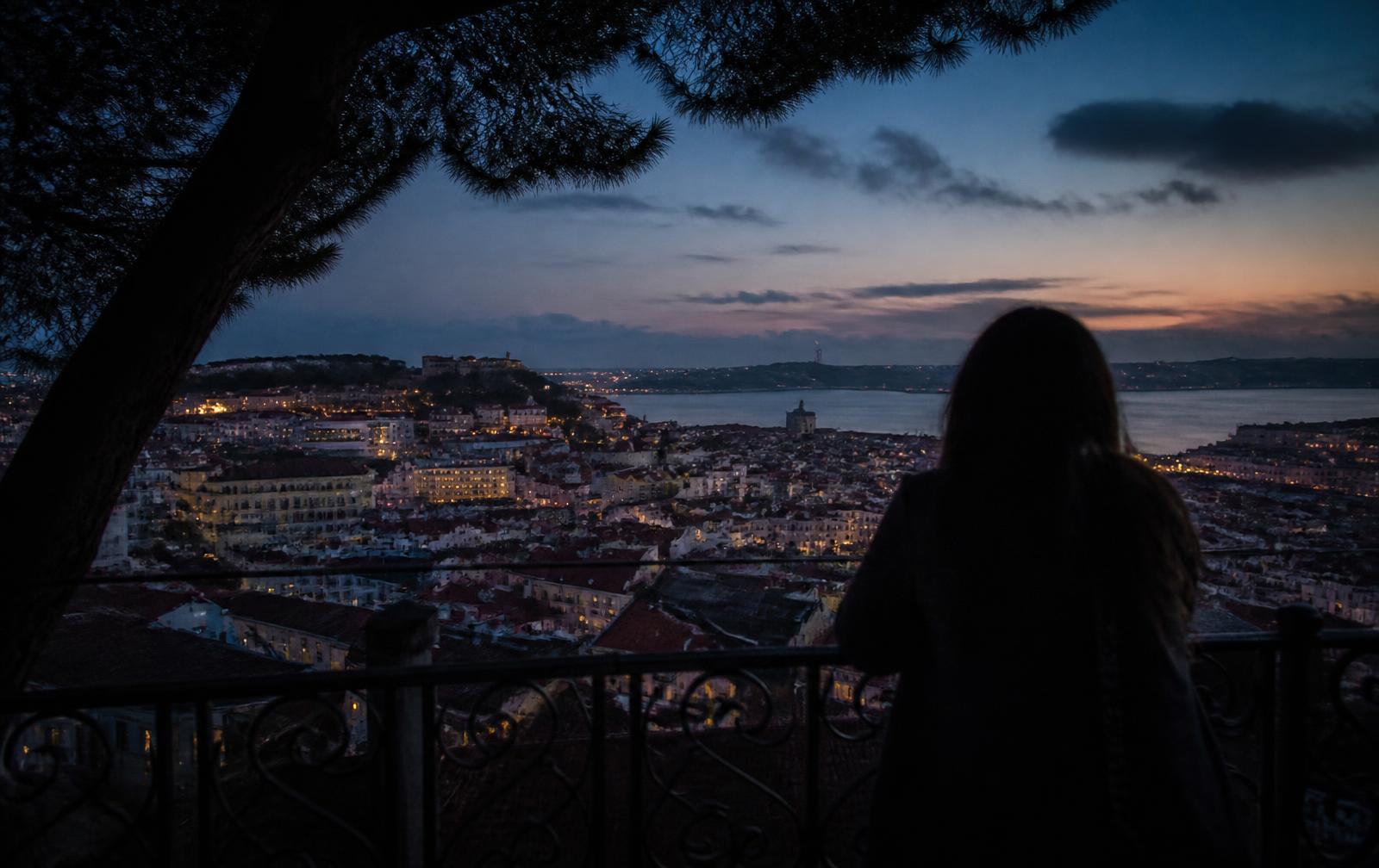 View over Lisbon rooftops from a miradouro at dusk